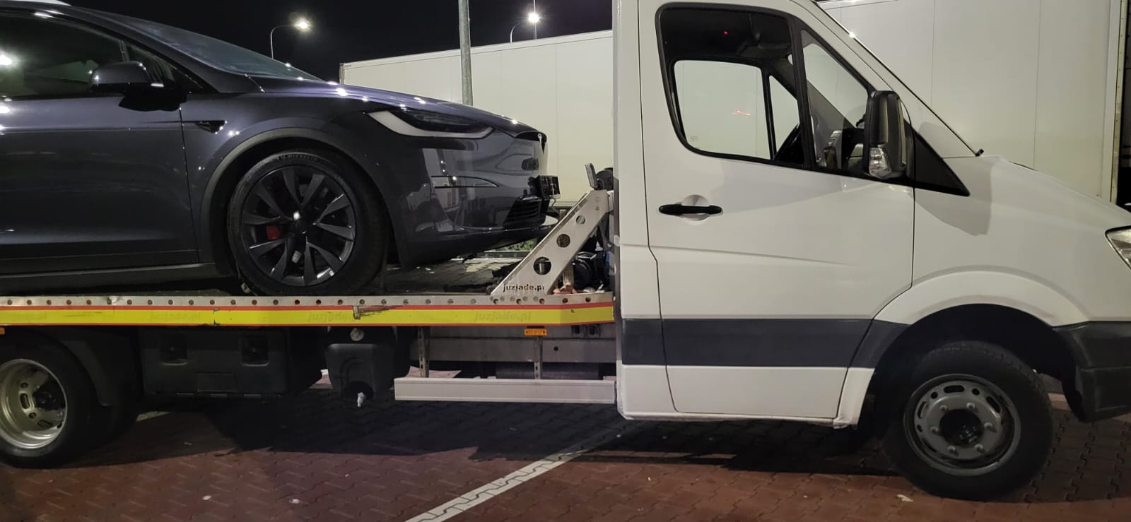 laweta z załadowanym autem elektrycznym marki tesla